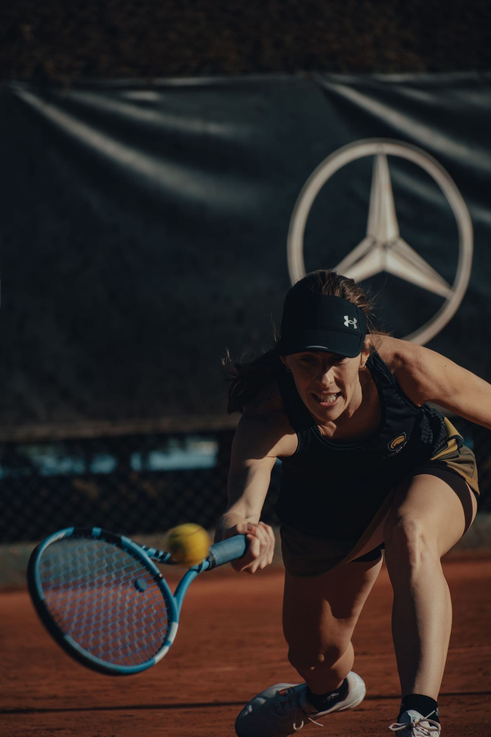 A woman stretching for a forehand during a session