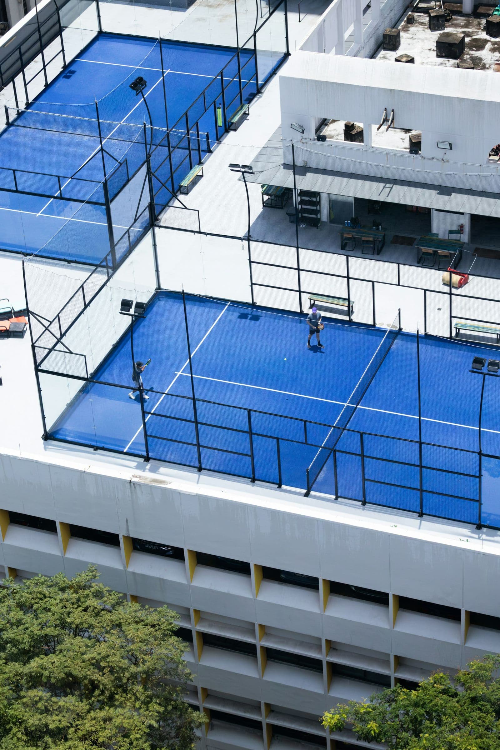 Padel courts on a residential tower rooftop, seen from above